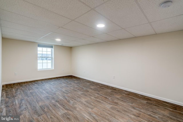 spare room with dark hardwood / wood-style floors and a drop ceiling