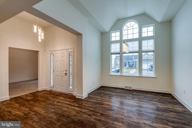 foyer featuring dark hardwood / wood-style floors, high vaulted ceiling, and a notable chandelier