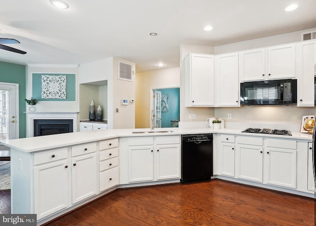 kitchen featuring white cabinetry, kitchen peninsula, dark wood-type flooring, and black appliances