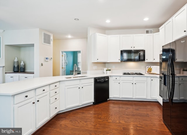 kitchen featuring white cabinetry, kitchen peninsula, sink, and black appliances