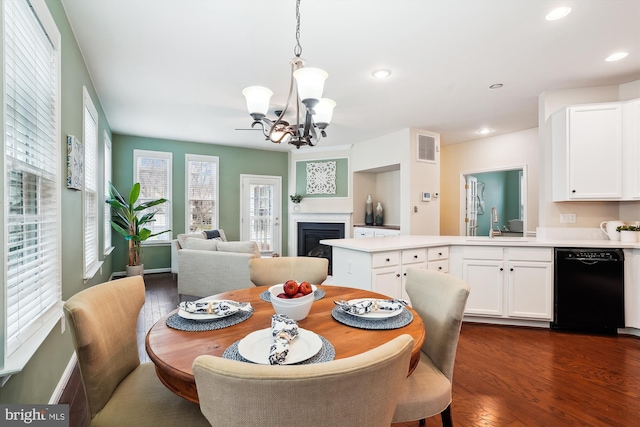 dining area featuring dark hardwood / wood-style floors, sink, and a notable chandelier