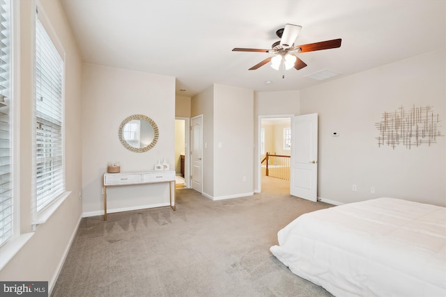 bedroom featuring connected bathroom, light carpet, and ceiling fan