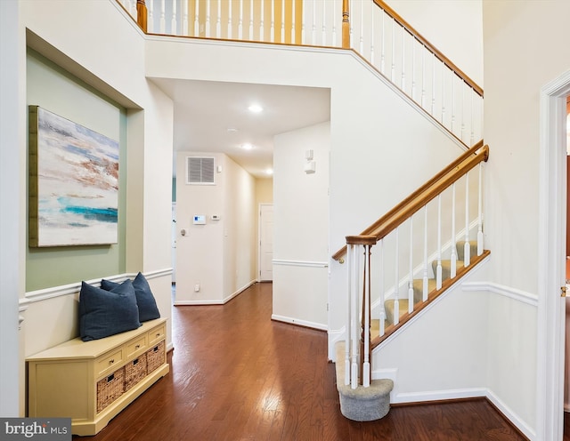 foyer with a towering ceiling and dark hardwood / wood-style flooring