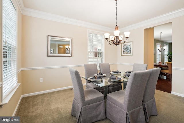 carpeted dining area featuring crown molding and a chandelier