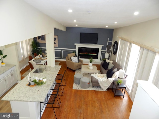 living room featuring sink and light hardwood / wood-style flooring