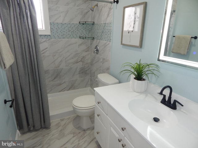 bathroom featuring tiled shower, vanity, and toilet