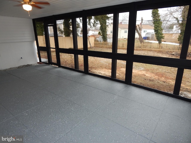 unfurnished sunroom featuring ceiling fan