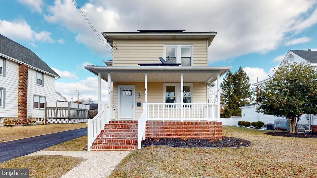 view of front facade featuring covered porch and a front yard