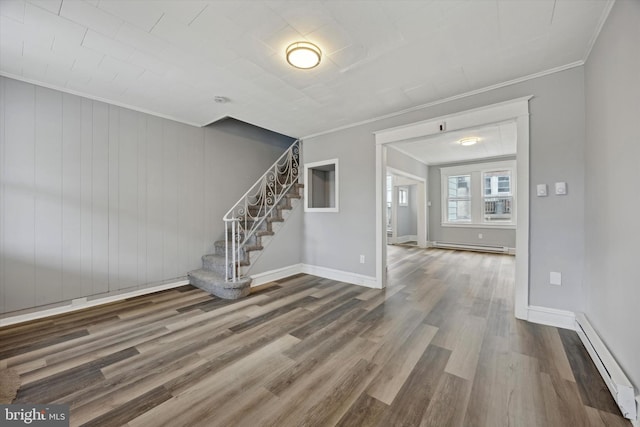 interior space featuring a baseboard heating unit, hardwood / wood-style flooring, and ornamental molding