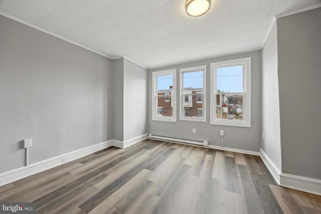 empty room featuring a baseboard radiator, wood-type flooring, and ornamental molding