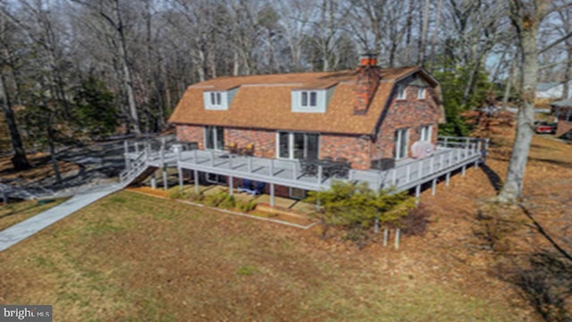 back of house featuring a wooden deck and a lawn