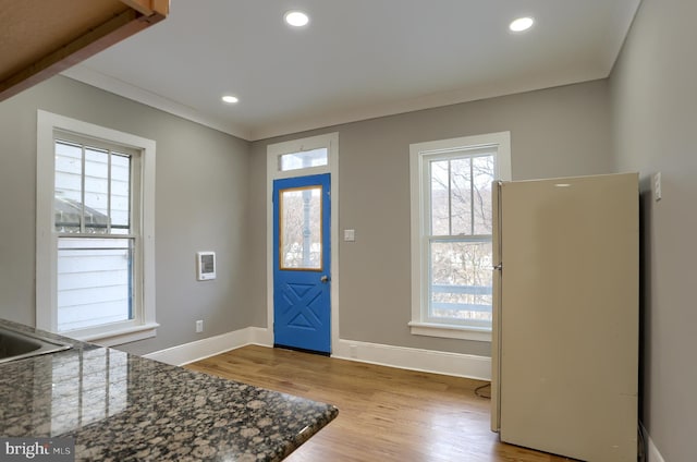 entryway featuring crown molding and light hardwood / wood-style flooring