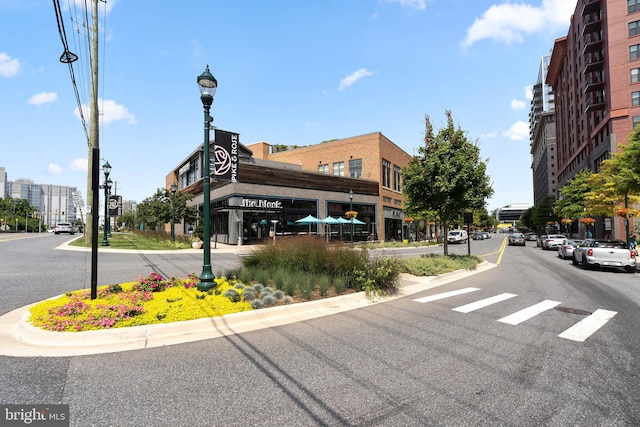 view of road with street lights, sidewalks, and curbs