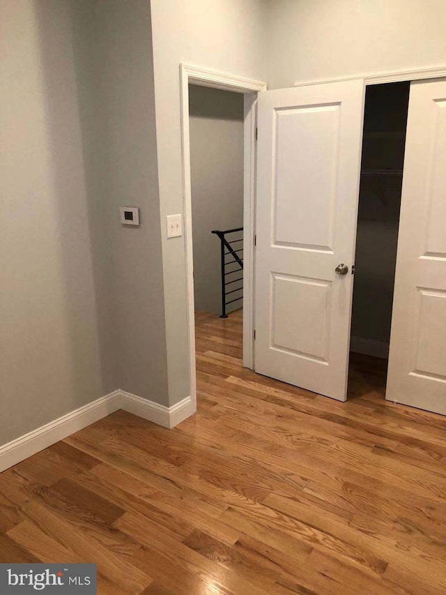 unfurnished bedroom featuring light hardwood / wood-style floors and a closet