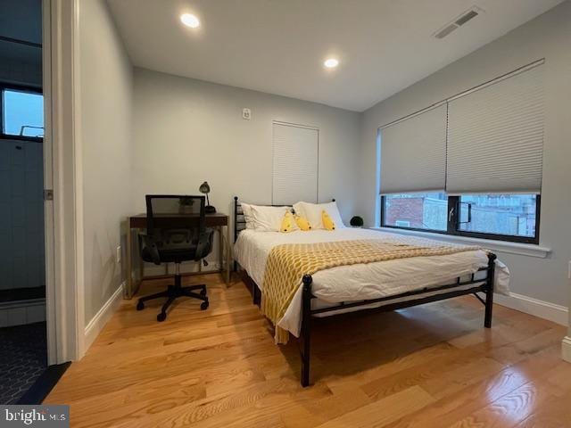 bedroom featuring light hardwood / wood-style floors and multiple windows