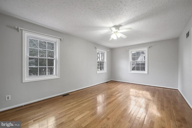 empty room featuring ceiling fan, a textured ceiling, and light wood-type flooring