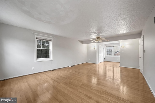 unfurnished living room featuring ceiling fan, a textured ceiling, and light hardwood / wood-style floors