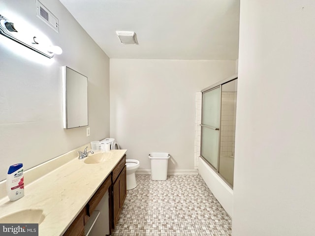 full bathroom featuring enclosed tub / shower combo, vanity, and toilet