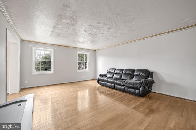 living room featuring crown molding, a textured ceiling, and light wood-type flooring