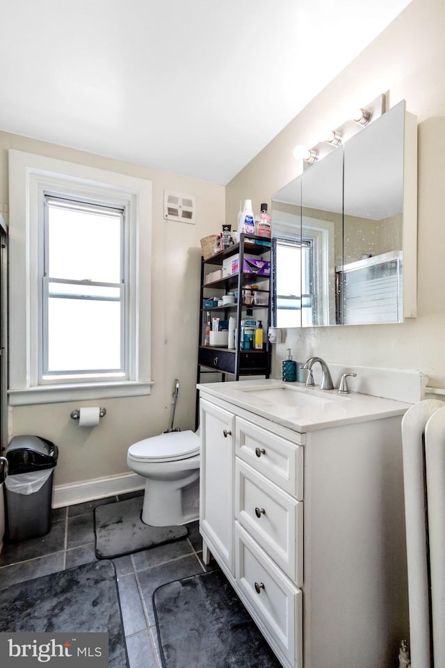 bathroom with vanity, plenty of natural light, an enclosed shower, and toilet