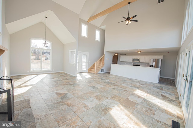 unfurnished living room featuring high vaulted ceiling and ceiling fan