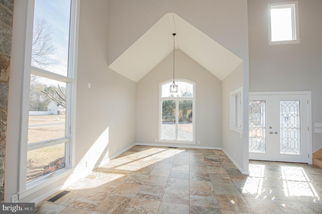 foyer entrance featuring a towering ceiling and french doors