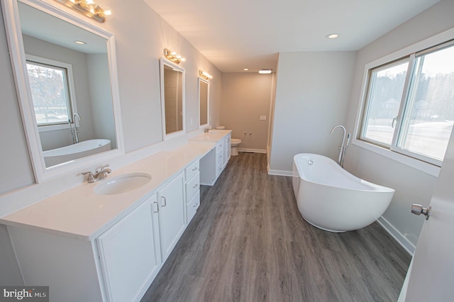 bathroom featuring vanity, toilet, a bathing tub, and hardwood / wood-style floors