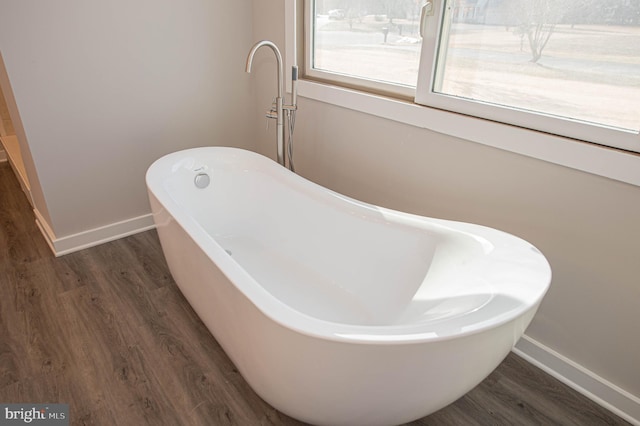 bathroom featuring a tub to relax in and wood-type flooring