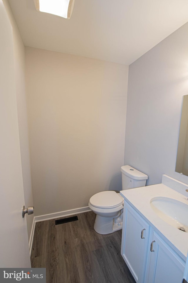 bathroom with vanity, wood-type flooring, and toilet