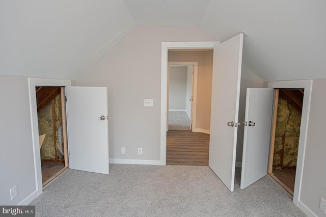 bonus room with light colored carpet and vaulted ceiling