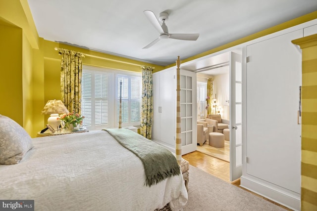 bedroom with parquet flooring, ceiling fan, and french doors