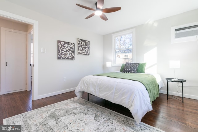 bedroom with ceiling fan, dark hardwood / wood-style floors, and a wall unit AC