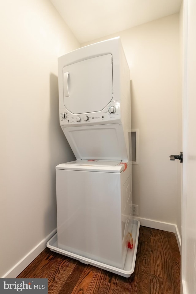 washroom featuring stacked washer and dryer and wood-type flooring