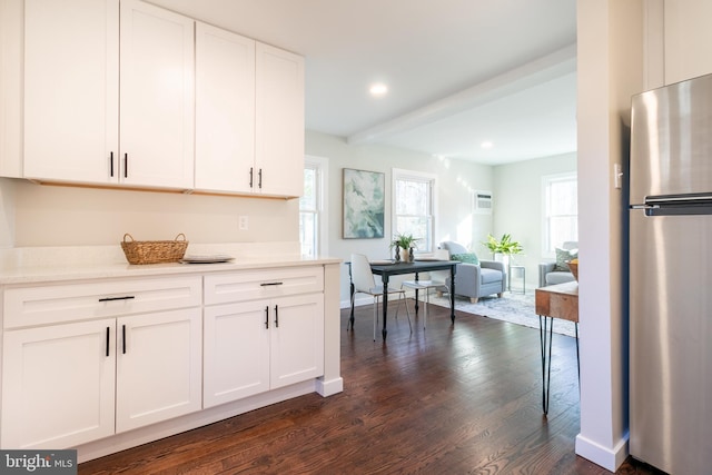 kitchen with white cabinetry, dark wood-type flooring, and stainless steel fridge