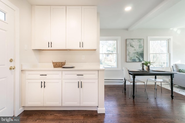 kitchen with beamed ceiling, dark wood-type flooring, and white cabinets