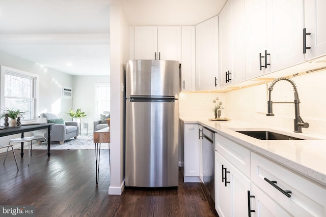 kitchen featuring sink, appliances with stainless steel finishes, dark hardwood / wood-style floors, light stone countertops, and white cabinets