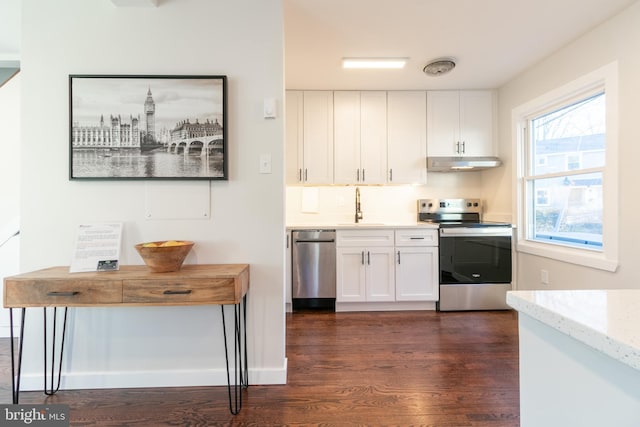 kitchen with dark wood-type flooring, stainless steel appliances, sink, and white cabinets