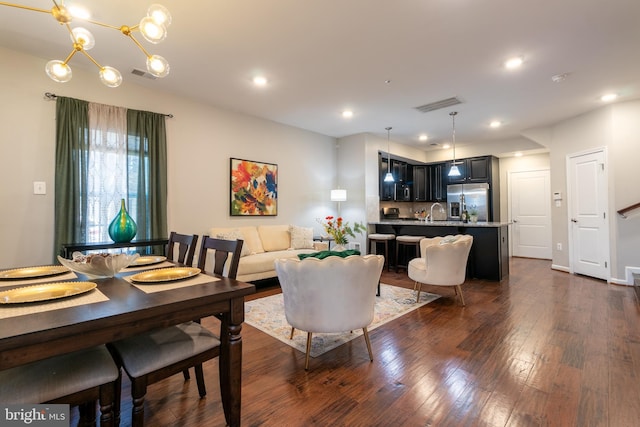 dining room featuring an inviting chandelier, dark hardwood / wood-style floors, and sink