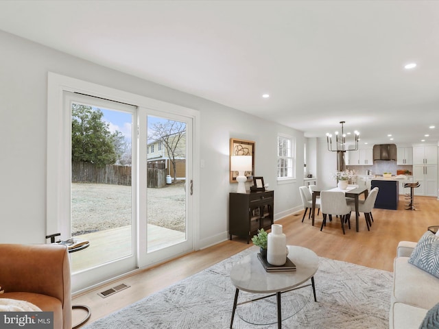 living room featuring a chandelier and light hardwood / wood-style floors