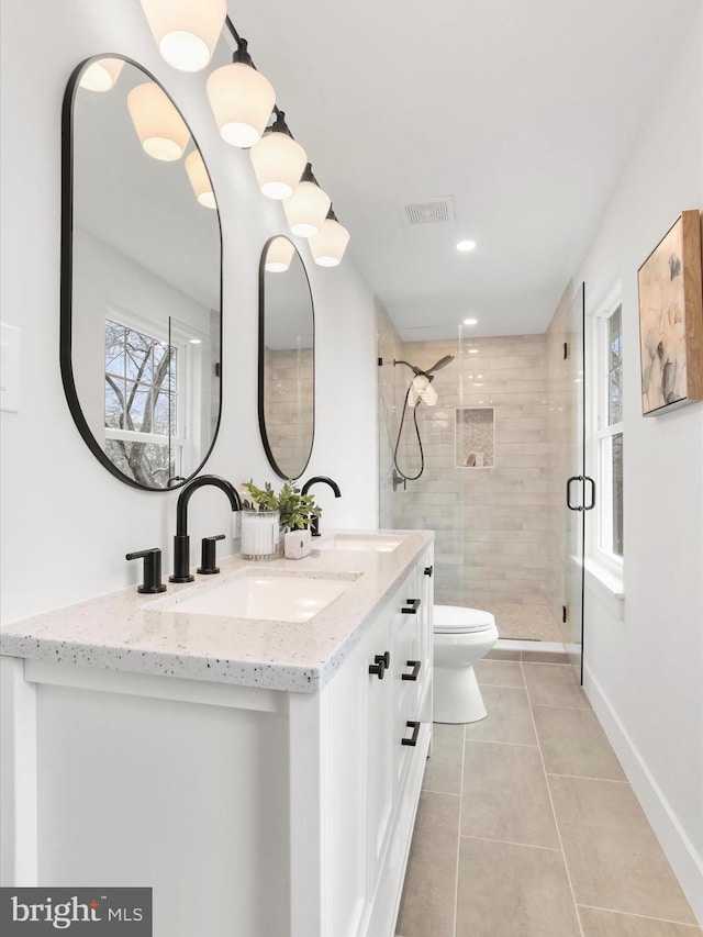 bathroom with vanity, toilet, an enclosed shower, and tile patterned flooring