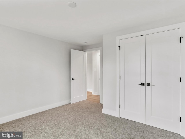 unfurnished bedroom featuring a closet and light carpet