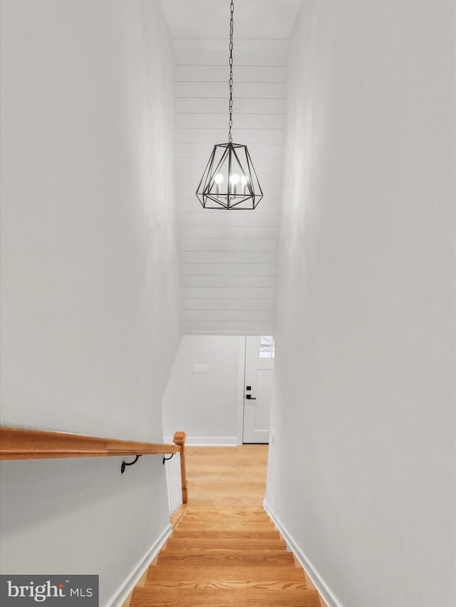 stairs featuring a notable chandelier and hardwood / wood-style flooring