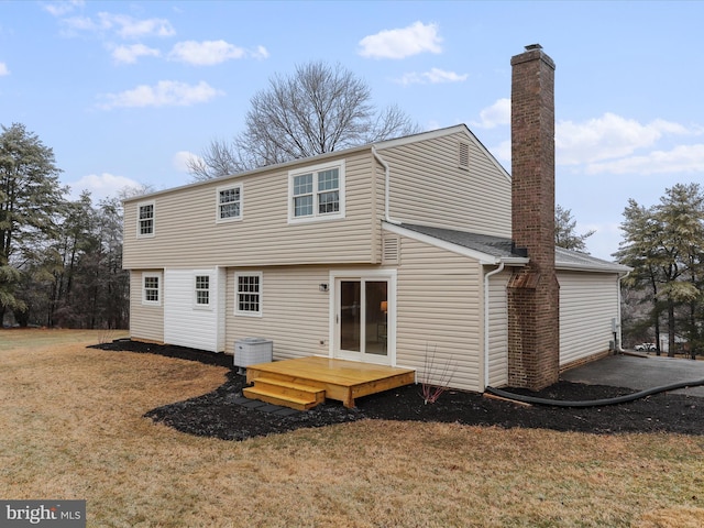 back of house featuring central AC unit and a yard