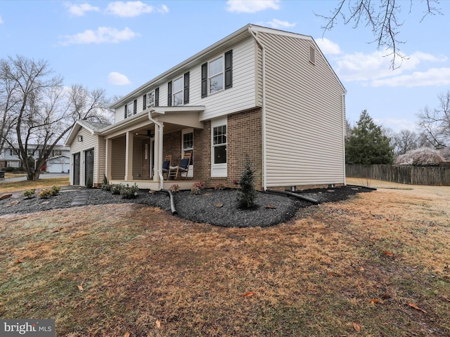 view of front facade with a garage, covered porch, and a front lawn