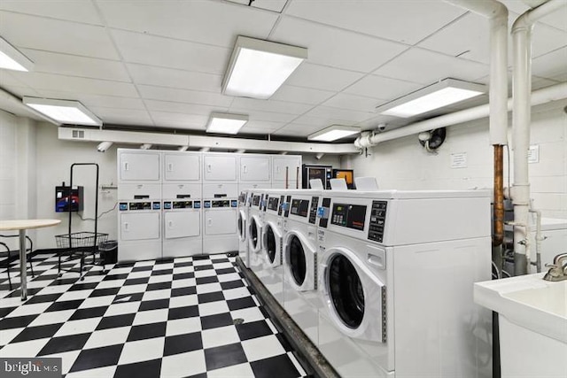 clothes washing area featuring washing machine and dryer, sink, and stacked washer / drying machine