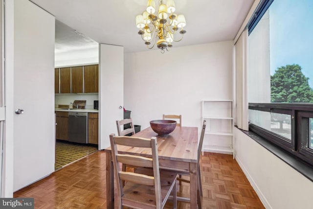 dining area featuring dark parquet flooring and an inviting chandelier