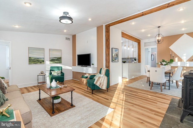 living room featuring a notable chandelier and light hardwood / wood-style flooring