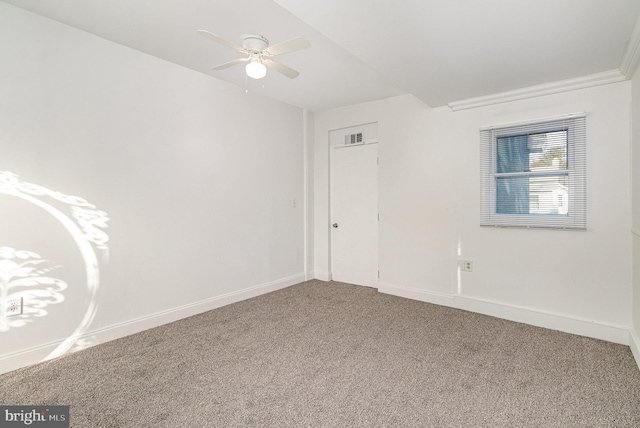 carpeted spare room featuring ceiling fan