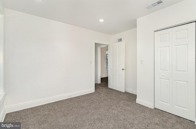 unfurnished bedroom with carpet flooring and a closet