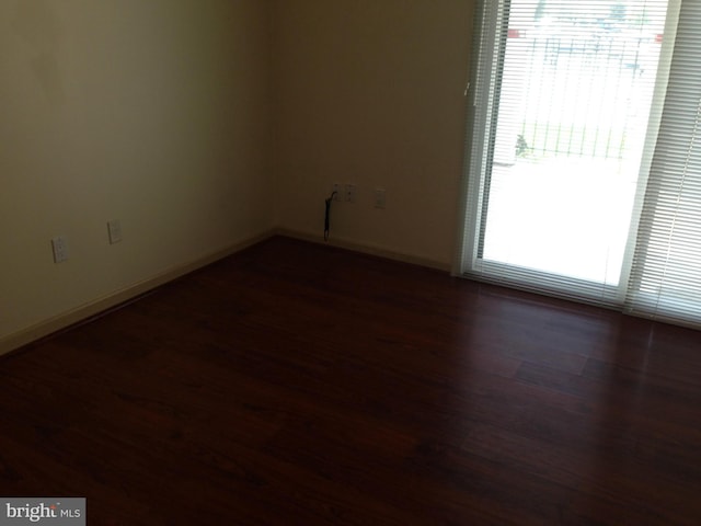 spare room featuring dark hardwood / wood-style floors and a wealth of natural light